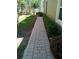 Manicured side yard with brick paver walkway and trimmed shrubs at 2305 Chatham Place Dr, Orlando, FL 32824