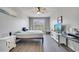 Neutral bedroom with wood-look floors, a ceiling fan, a window and a large tv on a console at 2348 Pearl Cider St, Orlando, FL 32824