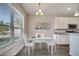 Bright dining area with modern table set, large window, and adjacent to a modern white kitchen at 2348 Pearl Cider St, Orlando, FL 32824