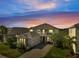 Charming two-story home featuring stone accents, a spacious garage, and a beautifully paved driveway at dusk at 2348 Pearl Cider St, Orlando, FL 32824