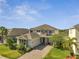 Beautiful two-story home featuring stone accents, a paver driveway, and mature landscaping at 2348 Pearl Cider St, Orlando, FL 32824
