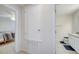 Hallway leading to a well-lit bedroom and bathroom with a neutral color scheme at 2348 Pearl Cider St, Orlando, FL 32824