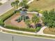 View of a well-maintained playground with modern equipment, surrounded by lush greenery and a secure fence at 2348 Pearl Cider St, Orlando, FL 32824