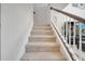 Carpeted stairs with white banister and a wood handrail at 2348 Pearl Cider St, Orlando, FL 32824