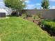 Manicured backyard with healthy green grass, lush landscaping, and a privacy fence at 2522 Nouveau Way, Kissimmee, FL 34741