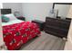 Cozy bedroom with a red blanket, neutral walls, and dark furniture at 2522 Nouveau Way, Kissimmee, FL 34741
