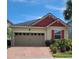 Charming single Gathering home featuring a brick paved driveway, 2 car garage, and red accents on the roof and window shutters at 2522 Nouveau Way, Kissimmee, FL 34741