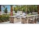 Outdoor grilling area with stone counters and stainless steel grills at 2522 Nouveau Way, Kissimmee, FL 34741
