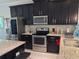 Modern kitchen featuring stainless steel appliances, granite countertops, and dark wood cabinetry at 2522 Nouveau Way, Kissimmee, FL 34741