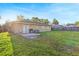 Backyard featuring a patio, sliding glass doors, small grill, and expansive grassy area at 2535 Georgia Ave, Sanford, FL 32773