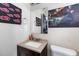 A cozy bathroom with a stylish vanity, paintings, mirror, and toilet at 2535 Georgia Ave, Sanford, FL 32773