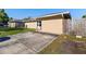 Beige single-story home featuring a concrete driveway, covered entryway, manicured lawn, and wooden privacy fence at 2535 Georgia Ave, Sanford, FL 32773