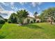 Beautiful home with a well-manicured lawn and mature landscaping, including palm trees and flowering shrubs at 271 Falling Waters Dr, Kissimmee, FL 34759