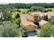 Aerial view of a yellow home with a brown roof, featuring a two-car garage and landscaped surroundings at 2724 Palm Tree Dr, Poinciana, FL 34759