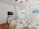 Well-lit bedroom featuring a bed with floral bedspread and TV on the wall at 2724 Palm Tree Dr, Poinciana, FL 34759