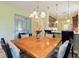 Charming dining area featuring a wooden table, chandelier, and seamless flow into the adjacent kitchen space at 2724 Palm Tree Dr, Poinciana, FL 34759