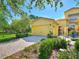 Charming yellow home features a brick driveway, well-manicured landscaping, and a two-car garage at 2724 Palm Tree Dr, Poinciana, FL 34759