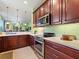 Well-designed kitchen featuring stainless steel appliances, wooden cabinets, and a view of the living area at 2724 Palm Tree Dr, Poinciana, FL 34759