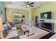 Open living room featuring comfortable seating, ceiling fan and sliding glass doors to backyard at 2724 Palm Tree Dr, Poinciana, FL 34759
