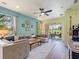 Spacious living room features a ceiling fan, comfortable seating and large windows for abundant light at 2724 Palm Tree Dr, Poinciana, FL 34759