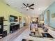 Spacious living room with modern furniture, hardwood floors, and an open layout connecting to the dining area at 2724 Palm Tree Dr, Poinciana, FL 34759