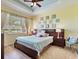Inviting bedroom with a king-size bed, ceiling fan, and natural light filtering through the expansive windows at 2724 Palm Tree Dr, Poinciana, FL 34759