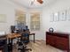 Bright home office with a wooden desk, organized workspace, and natural light from the windows at 2724 Palm Tree Dr, Poinciana, FL 34759
