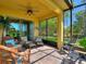 Enclosed patio showcasing tiled floors, comfortable seating, and a scenic view of the lush surroundings outdoors at 2724 Palm Tree Dr, Poinciana, FL 34759