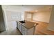 Bright kitchen boasts a large island with a sink, neutral countertops, and stainless steel appliances at 3041 Tobago Dr, Haines City, FL 33844