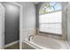 Bright bathroom featuring a soaking tub and a large window providing natural light at 3111 Turnberry Blvd, Kissimmee, FL 34744