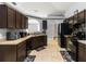 Well-lit kitchen featuring brown cabinetry, tile flooring, and modern appliances at 3111 Turnberry Blvd, Kissimmee, FL 34744