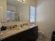 Bathroom with double vanity with granite countertops and dark cabinetry at 320 Aberdeen Dr, Davenport, FL 33896