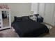 Well-lit bedroom with a dark-striped comforter and a white cabinet at 320 Aberdeen Dr, Davenport, FL 33896