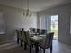 Dining room with large table, chandelier, tile flooring, and sliding glass door to backyard at 320 Aberdeen Dr, Davenport, FL 33896