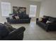 Living room featuring neutral colors, tile floors, and comfortable leather sofas at 320 Aberdeen Dr, Davenport, FL 33896