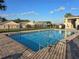 Community pool with brick pavers, metal fence, and nearby clubhouse at 320 Aberdeen Dr, Davenport, FL 33896