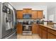 Well-equipped kitchen featuring stainless steel appliances, wood cabinets, granite countertops, and a tile floor at 3610 Rodrick Cir, Orlando, FL 32824