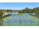Tennis courts with a serene lake and mature trees in the background at 3610 Rodrick Cir, Orlando, FL 32824