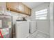 Functional laundry room featuring a washer, dryer, water heater, and cabinets at 412 Noya Ln, Apopka, FL 32712