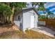 The storage building features painted siding, a white door, and outdoor lighting at 412 Noya Ln, Apopka, FL 32712