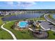 A high-angle drone shot of a community pool, playground, lake, and parking lot at 4190 Bull St, St Cloud, FL 34772