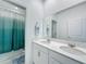 Bathroom featuring double sinks with granite countertops, a large mirror and a shower-tub combo at 4190 Bull St, St Cloud, FL 34772