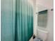 Close-up of a bathroom featuring a toilet, towel rack and a shower-tub with modern curtain at 4190 Bull St, St Cloud, FL 34772