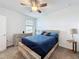 This bedroom features a wood bed frame, a ceiling fan, and carpet flooring at 4190 Bull St, St Cloud, FL 34772