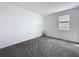A cozy bedroom with plush carpeting and a bright window is lit with a bedside lamp at 4190 Bull St, St Cloud, FL 34772