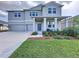 Inviting two-story home featuring a two-car garage, covered entry, and neatly arranged landscaping at 4190 Bull St, St Cloud, FL 34772