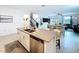Bright kitchen island with stainless steel dishwasher and sink, open to living spaces and staircase at 4190 Bull St, St Cloud, FL 34772