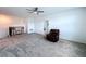 Spacious upstairs living room with carpet, fan, and stairs to the lower level at 4190 Bull St, St Cloud, FL 34772