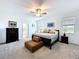 Bright main bedroom with carpet, ceiling fan, and a brown leather bench at 4190 Bull St, St Cloud, FL 34772