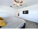 Comfortable primary bedroom featuring a ceiling fan, and TV; doorway to bathroom; minimal decor at 4190 Bull St, St Cloud, FL 34772